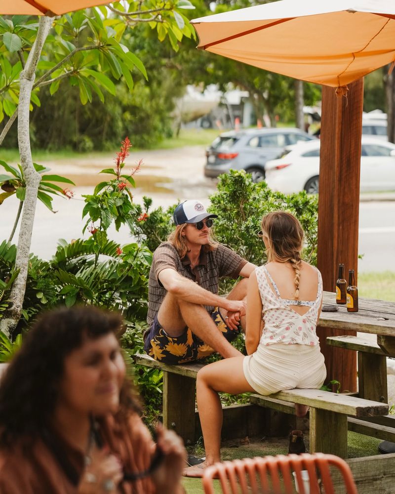 Guests relaxing at garden tables under orange umbrellas